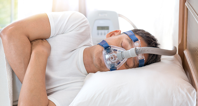 Hombre dormido con un CPAP (tratamiento para la apnea del sueo).